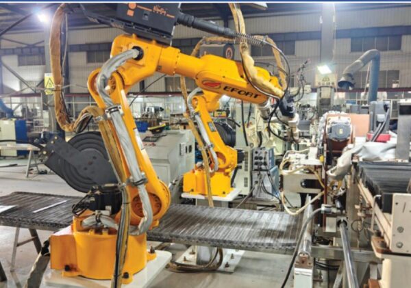 A machine weaving stainless steel wire into a conveyor belt.