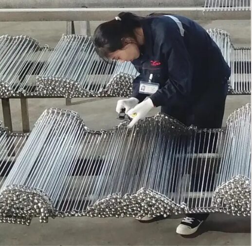 An overview shot of a complete spiral freezer belt system.(https://www.yiyimeshbelt.com/wp-content/uploads/2026/01/spring-freezer-belt-overview.jpg)
Let me explain a little more about these crucial components. Spiral freezer belts are typically made from stainless steel or other high-performance alloys. They are designed for durability and hygiene in demanding environments. We at YIYI Mesh Belt specialize in crafting these robust solutions. These belts feature an open mesh design, which allows for optimal air or heat circulation around the product. This design helps ensure even freezing or heating. The spiral configuration maximizes throughput in a minimal footprint. This makes them highly efficient for industrial applications.
Here is a quick overview of common spiral freezer belt types and their applications:
| Belt Type | Material | Common Applications | Key Features |
|---|---|---|---|
| Balanced Weave Belt | Stainless Steel | IQF, Baking, Roasting | High strength, good air flow, versatile |
| Compound Balanced Weave | Stainless Steel | Heavy-duty freezing, bakery products | Tighter mesh, suitable for smaller products |
| Rod-Reinforced Belt | Stainless Steel | High-temperature ovens, heavy product transport | Very strong, minimal deformation under load |
| Ladder Belt | Stainless Steel | Blanching, washing, light product transfer | Simple design, easy to clean, cost-effective |
Understanding these types helps you choose the right belt for your specific needs, ensuring optimal performance and longevity. From my experience, a well-chosen belt can make all the difference in a busy production facility.
How are Spiral Freezer Belts Manufactured, Anyway?
Are you wondering why some belts perform better than others? The difference often lies in the precision and care taken during the manufacturing process. Poorly made belts can lead to constant headaches and unexpected breakdowns.
Understanding how spiral freezer belts are made reveals why quality control, especially around welds, is so important. This process involves several critical steps to ensure durability and proper function.
The manufacturing of spiral freezer belts is a detailed process that begins with selecting the right raw materials. We primarily use high-grade stainless steel wire. This choice ensures resistance to corrosion and extreme temperatures. The wires are then precisely formed and interwoven to create the specific mesh pattern. This pattern depends on the belt's intended application. After the mesh is formed, individual sections are joined together using welding. This step is critical for the belt's overall integrity and strength. We pay close attention to the welding process because it directly impacts the belt's performance. Our recent investments in advanced machinery, like the stainless steel coil wire drawing machine and round bar drawing equipment, costing USD 400,000 and USD 360,000 respectively, allow us to achieve higher precision in every step. This helps us ensure that the raw materials and finished products meet stringent quality standards.
Here's a breakdown of the key stages in our manufacturing process:
| Stage | Description | Critical Quality Point |
|---|---|---|
| Material Selection | Choosing high-grade stainless steel or other alloys. | Ensuring material purity and appropriate mechanical properties. |
| Wire Drawing & Forming | Drawing raw coils into specific wire diameters and shaping them. | Maintaining precise wire gauge and consistent forming for mesh integrity. |
| Mesh Weaving/Assembly | Interweaving wires to form the belt's structure and pattern. | Achieving uniform mesh spacing and tension across the belt. |
| Welding & Joining | Connecting individual belt sections or components, particularly at edges. | Ensuring strong, clean welds with minimal burr formation. |
| Finishing & Polishing | Smoothing surfaces, removing sharp edges, and cleaning the belt. | Thorough removal of all burrs, sharp points, and surface imperfections. |
| Quality Inspection | Comprehensive checks for dimensions, weld integrity, and overall quality. | Verifying compliance with all design specifications and performance metrics. |
Every stage is important, but the welding and finishing stages are where we focus heavily on preventing burrs, which as you know, can cause many problems down the line.
What are Spiral Freezer Belt Edge Weld Burrs?
Are you experiencing mysterious scratching or black residue in your processing equipment? The culprit might be something you can barely see: a weld burr. These small imperfections can cause big headaches.
Weld burrs on spiral freezer belts are tiny, sharp protrusions of excess material that remain after the welding process. They often occur at the points where individual wires or sections of the belt are joined together.
Let me tell you about the impact of these small but mighty imperfections. When a spiral freezer belt is installed in equipment, especially in a traditional friction-driven system, the inner side welds are constantly under tension. They often press tightly against the equipment's U-shaped bars. If these welds have even minor burrs, the burrs will frictionally rub against the U-bars. This rubbing creates scratches, which deepen over time. As the equipment continues to operate, these scratches on the U-bars generate fine, dark, shaving-like metallic particles. These tiny black residues accumulate and can stick to the weld points. What's worse, at the inlet and outlet of the equipment, these black residues can be blown by cold air fans. This leads to contamination of IQF products, workpieces, or food items. I have seen this cause major contamination events. These events result in significant production of substandard products and severe economic losses. It is a problem that my clients want to avoid at all costs, and so do I.
To further illustrate the potential issues, consider this table showing the direct and indirect impacts of weld burrs:
| Type of Impact | Description | Immediate Consequence | Long-Term Consequence |
|---|---|---|---|
| Mechanical Wear | Burrs abrade against U-bars, causing scratches and metal shavings. | Increased friction, potential for belt sticking. | Premature wear of U-bars, increased maintenance needs, equipment damage. |
| Product Contamination | Metal shavings become airborne and settle on products. | Product discoloration, foreign material presence. | Product recalls, brand reputation damage, compliance issues. |
| Hygiene Risks | Burrs can trap food particles, creating breeding grounds for bacteria. | Difficult cleaning, potential for microbial growth. | Food safety hazards, regulatory fines. |
| Operational Efficiency | Increased friction leads to higher power consumption and potential jams. | Decreased throughput, increased energy costs. | Reduced operational lifespan of equipment, higher overall operating costs. |
| Economic Loss | Costs associated with contaminated products, repairs, and downtime. | Scrap material, immediate financial impact. | Loss of contracts, decreased profitability, long-term market trust erosion. |
This table clearly shows why even a tiny burr is not just a cosmetic issue but a critical operational hazard.
What are the Metal Conveyor Belt Production SOPs to Remove Those Burrs?
Are you concerned about burrs on your conveyor belts impacting product quality? Preventing these issues is all about having a robust, standardized manufacturing process. Without clear procedures, you're leaving quality to chance.
At YIYI Mesh Belt, we have established strict Standard Operating Procedures (SOPs) specifically designed to eliminate weld burrs and ensure the highest quality of our metal conveyor belts. These SOPs cover every stage of production where burrs might occur.
![A worker carefully finishing and inspecting a metal conveyor belt.