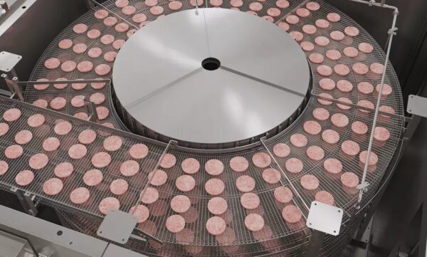 Burger patties conveyed on a spiral freezer belt in an IQF system