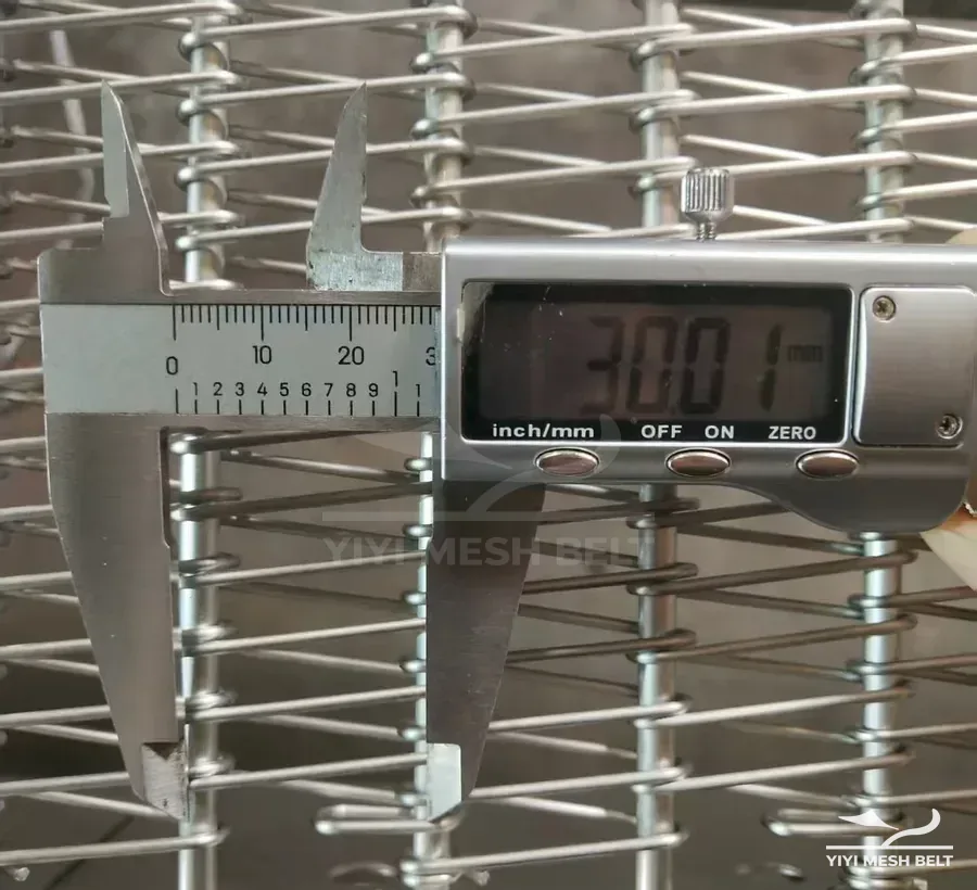 YIYI Mesh Belt self-stacking belt rod pitch measured with a digital caliper while a customer sample is turned into a drawing