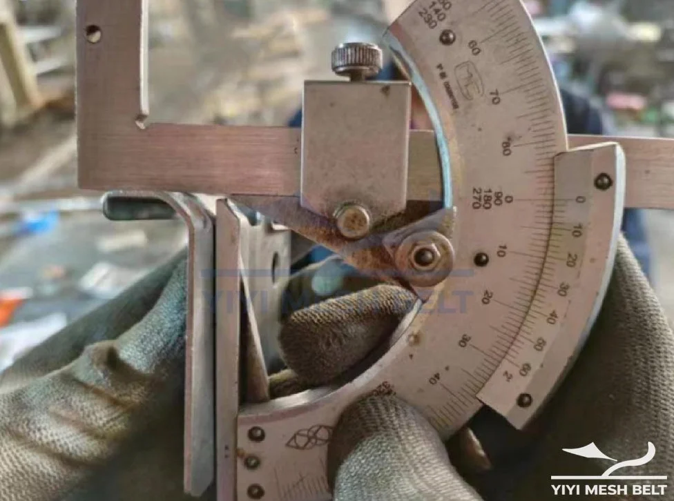 YIYI Mesh Belt inspector measuring the stacking plate angle of a self-stacking belt with an angle gauge